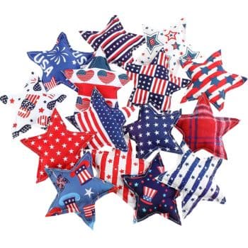 A collection of fabric stars decorated with various red, white, and blue patriotic patterns, including stripes, polka dots, stars, plaid, and American flag designs, arranged in a scattered pile.