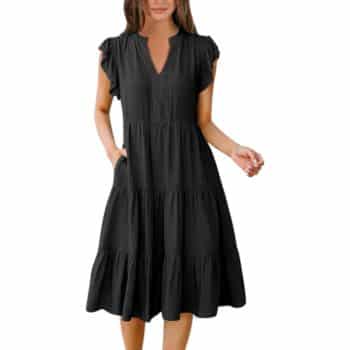 Woman wearing a loose-fitting, short-sleeve, knee-length black dress with a V-neckline and tiered ruffle design.