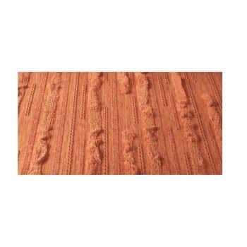 Close-up of a textured, rust-colored fabric with a combination of raised, tufted stripes and flat woven sections.