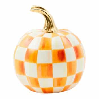 A decorative pumpkin with an orange and white checkered pattern and a gold stem, set against a white background.