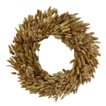 A circular wreath made of dried brown grasses and seed heads, arranged densely to form a textured, rustic decoration against a white background.