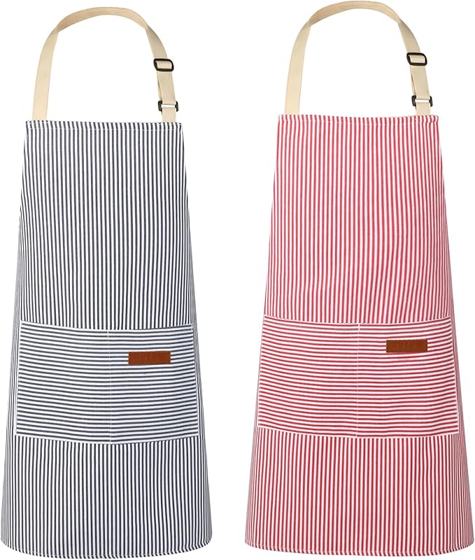 Two striped aprons with front pockets—ideal for tackling a flying dutchman burger recipe—are displayed side by side; one has black and white stripes, the other red and white. Both feature beige neck straps and a brown patch on the pocket.