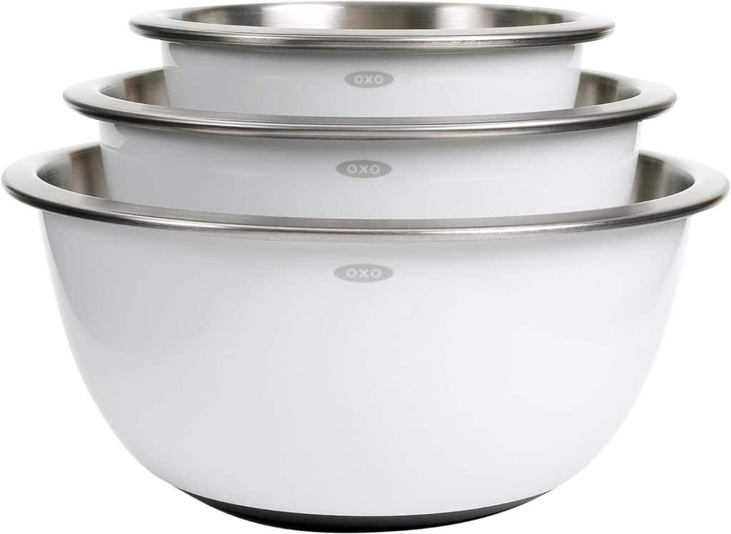 Three white stainless steel mixing bowls of varying sizes, nested inside each other with the OXO logo visible—perfect for prepping all your ingredients for a flying dutchman burger recipe.