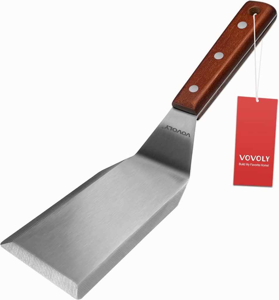 A stainless steel spatula with a wooden handle featuring three rivets, ideal for flipping patties when making a flying dutchman burger recipe, and a red tag labeled "VOVOLY" attached to the handle.