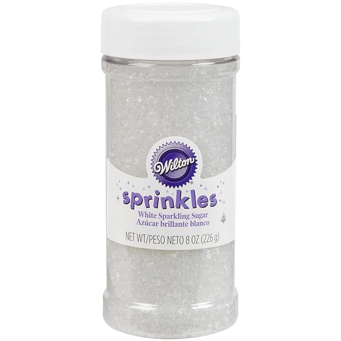 A plastic container of Wilton brand white sparkling sugar sprinkles with a white lid and a label showing the product name and weight (8 oz/226 g). Perfect for topping your favorite lemon sugar cookie recipe, the sprinkles inside appear clear and crystalline.