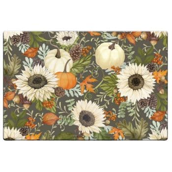 A decorative mat with a fall-themed pattern featuring white sunflowers, orange and white pumpkins, pinecones, autumn leaves, and green foliage on a dark background.