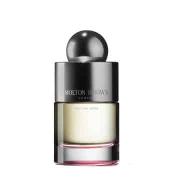 A bottle of Molton Brown perfume with a spherical silver cap, a silver label, and clear glass showing pale yellow liquid inside. The scent name "Fiery Pink Pepper" is printed below the brand logo.