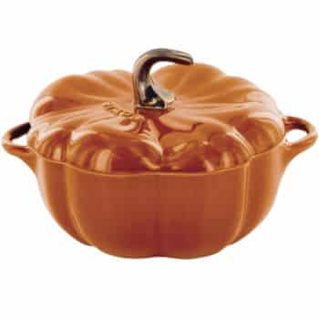 Orange ceramic casserole dish shaped like a pumpkin, perfect for lovers of all things pumpkin, featuring a brown stem-shaped handle on the lid and two side handles.
