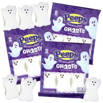 Packages of Peeps Marshmallow Ghosts, featuring white ghost-shaped marshmallow treats with black eyes and mouths—perfect halloween treats. Some ghosts are outside the packaging, displayed in front of the bags.