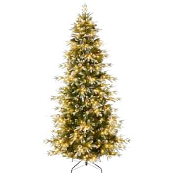 A tall artificial Christmas tree with dense branches, decorated with warm white string lights, standing on a metal stand against a plain background.