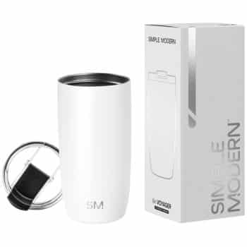 A white Simple Modern insulated tumbler with a clear lid and black handle is shown next to its packaging box, which displays the product image and the brand name "SIMPLE MODERN.