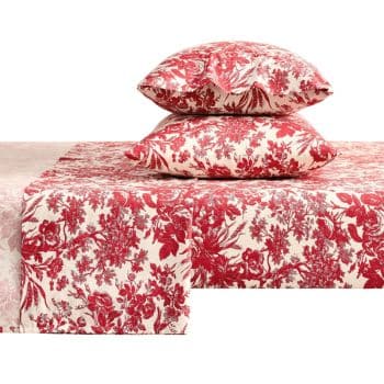 A set of bedding with two stacked pillows and a sheet, all featuring a red floral and foliage pattern on a white background.