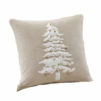 A beige throw pillow featuring a textured white Christmas tree with small gold and white decorative accents on the front.
