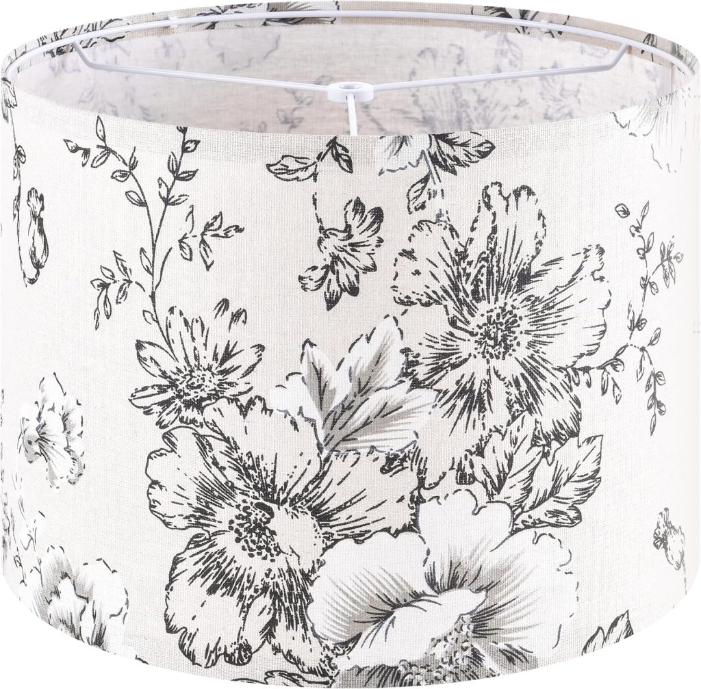 A cylindrical lampshade with a light beige background and detailed black floral patterns, featuring large blooming flowers and leafy branches—perfect for cozy wall crafts for fall.