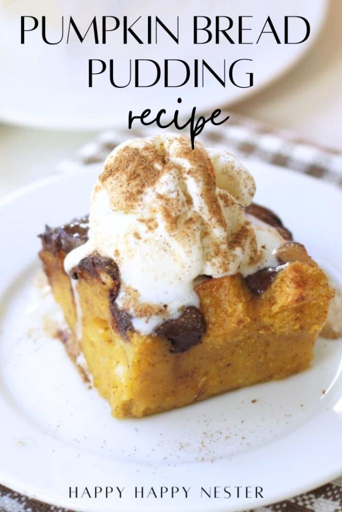 A slice of pumpkin bread pudding, made from a classic pumpkin bread pudding recipe, is topped with whipped cream and a sprinkle of cinnamon on a white plate. Text above reads “Pumpkin Bread Pudding Recipe,” and below is “Happy Happy Nester.”.