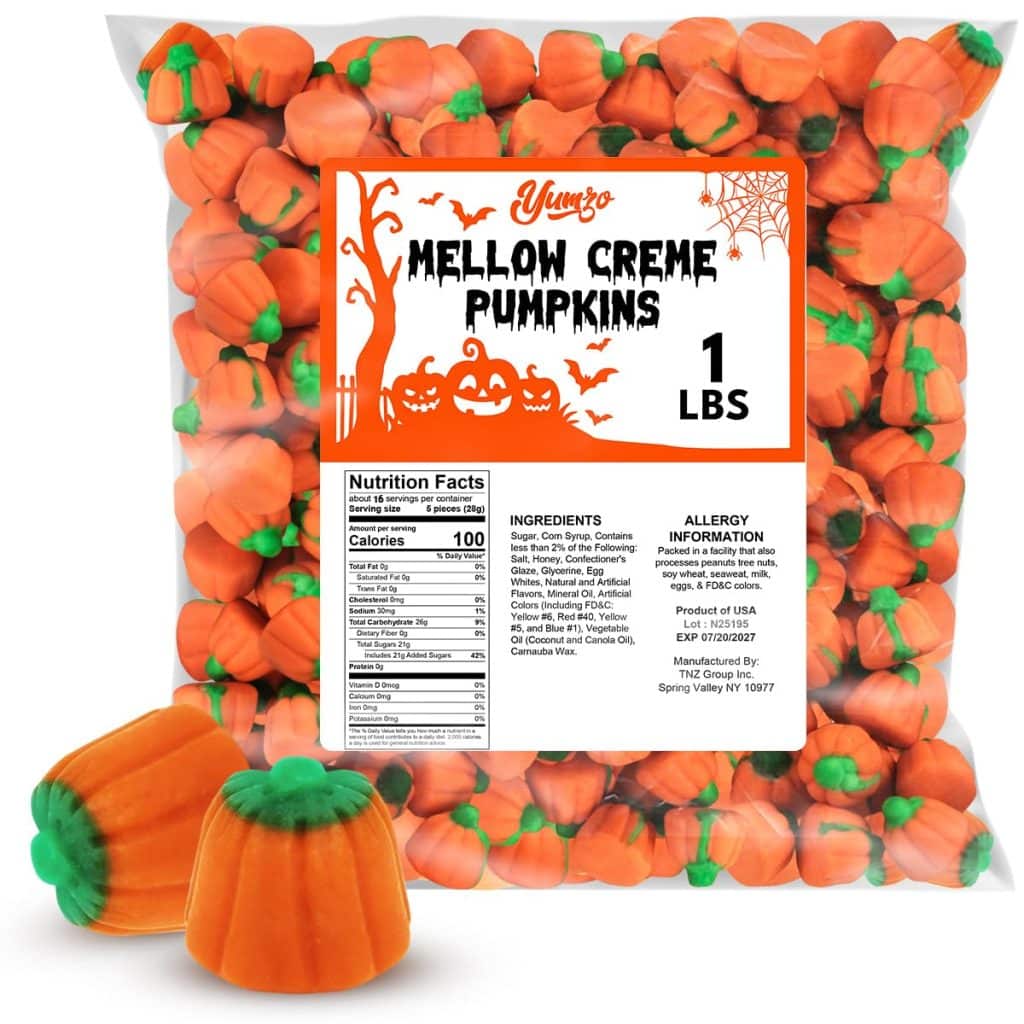 A clear bag labeled "Yumzo Mellow Creme Pumpkins 1 lbs" filled with orange, pumpkin-shaped candy with green tops—perfect for adding to your favorite Halloween bark recipe. Two candies are displayed outside the bag in the foreground.