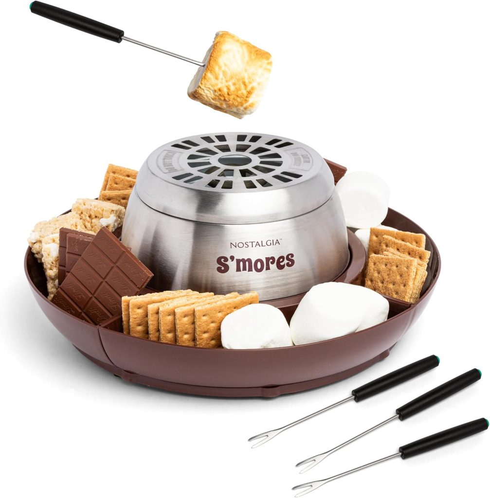 A tabletop stainless steel S’mores maker sits on a tray with graham crackers, chocolate bars, marshmallows, and four roasting forks—perfect for making Thanksgiving treats with family and friends.