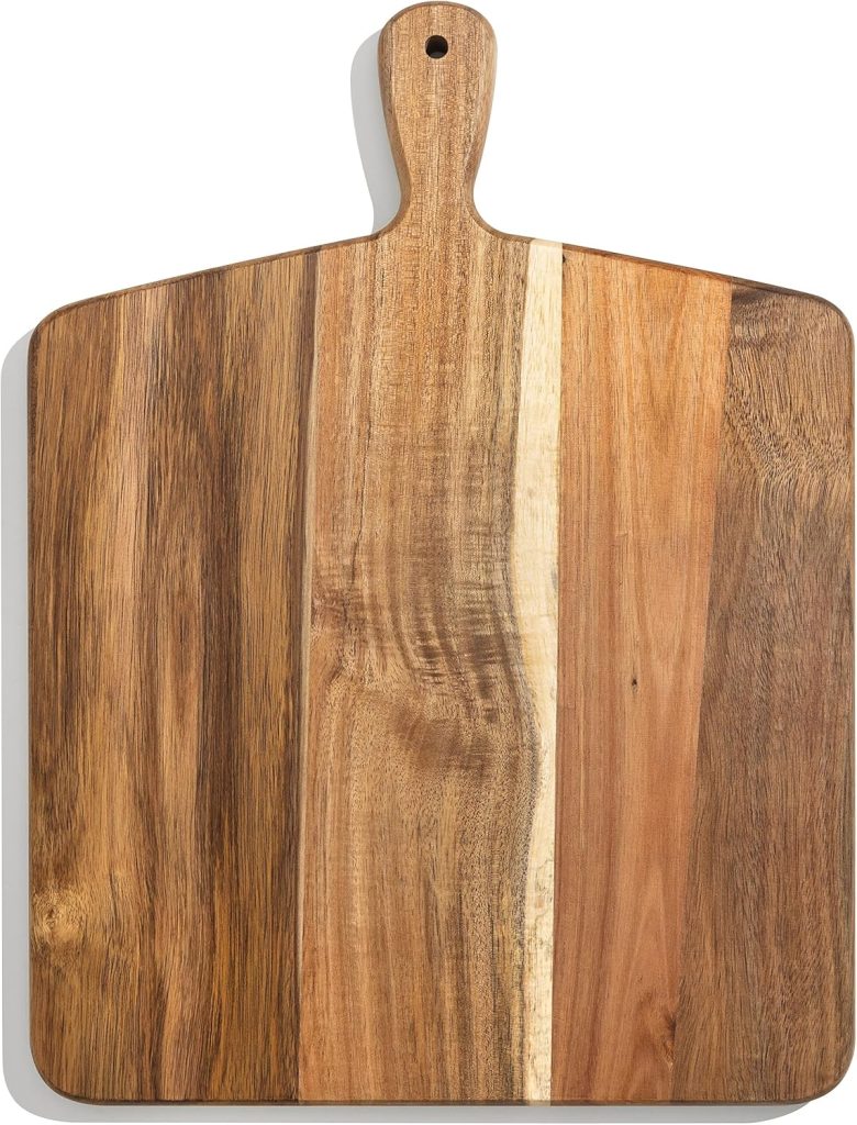 A rectangular wooden cutting board with a handle, featuring multiple shades and grains of wood, displayed on a white background—perfect for serving your favorite pumpkin bread pudding recipe.
