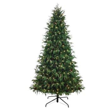A tall, artificial Christmas tree with green branches, decorated with small white lights, standing on a metal tree stand against a plain white background.