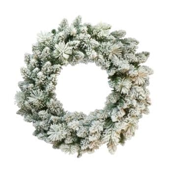 A circular Christmas wreath made of pine branches covered in artificial snow, giving it a frosted, wintry appearance, set against a plain white background.