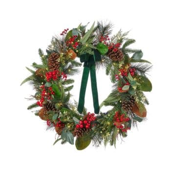 A festive holiday wreath decorated with pinecones, red berries, green leaves, and a dark green velvet ribbon bow at the top.