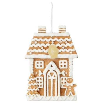 A gingerbread house ornament decorated with white icing, featuring a door, windows, a small Christmas tree, and a gingerbread person, with a string on top for hanging.