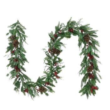 A festive holiday garland made of green pine branches, red berries, and pinecones, arranged in a loose, wavy shape against a white background.