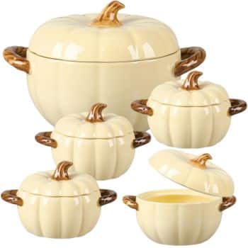 A set of five cream-colored ceramic soup bowls and tureens shaped like pumpkins, perfect for serving Thanksgiving food; each features brown handles and stems, with one bowl’s lid removed and placed to the side.
