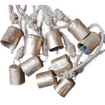 A cluster of small, metal cowbells hangs from thick, twisted ropes. The bells are rustic and have a slightly worn appearance, with clappers visible inside some of them.