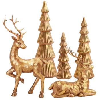 Two gold-colored reindeer figurines, one standing and one lying down, are displayed in front of four gold, stylized Christmas tree ornaments of varying heights.