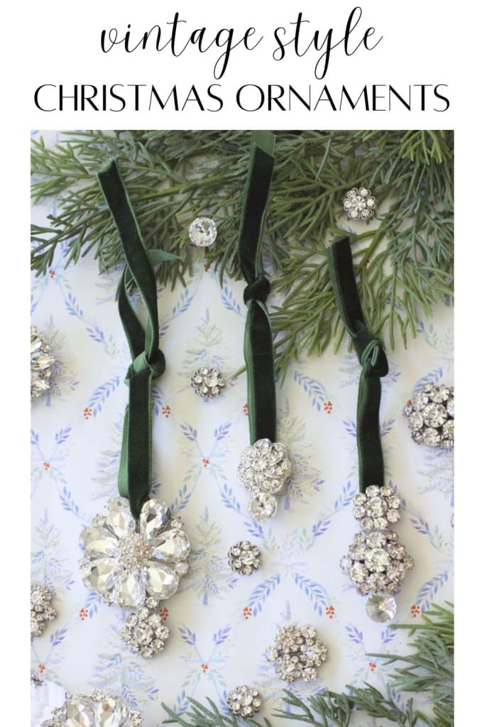 Three vintage-style Christmas ornaments DIY projects sparkle with crystal accents and green velvet ribbons, hanging among evergreen branches and surrounded by small matching jeweled decorations on patterned paper.
