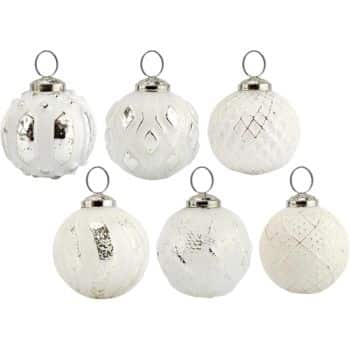 Six white glass Christmas ornaments with silver caps, each featuring different textured and etched patterns, arranged in two rows of three against a plain white background.