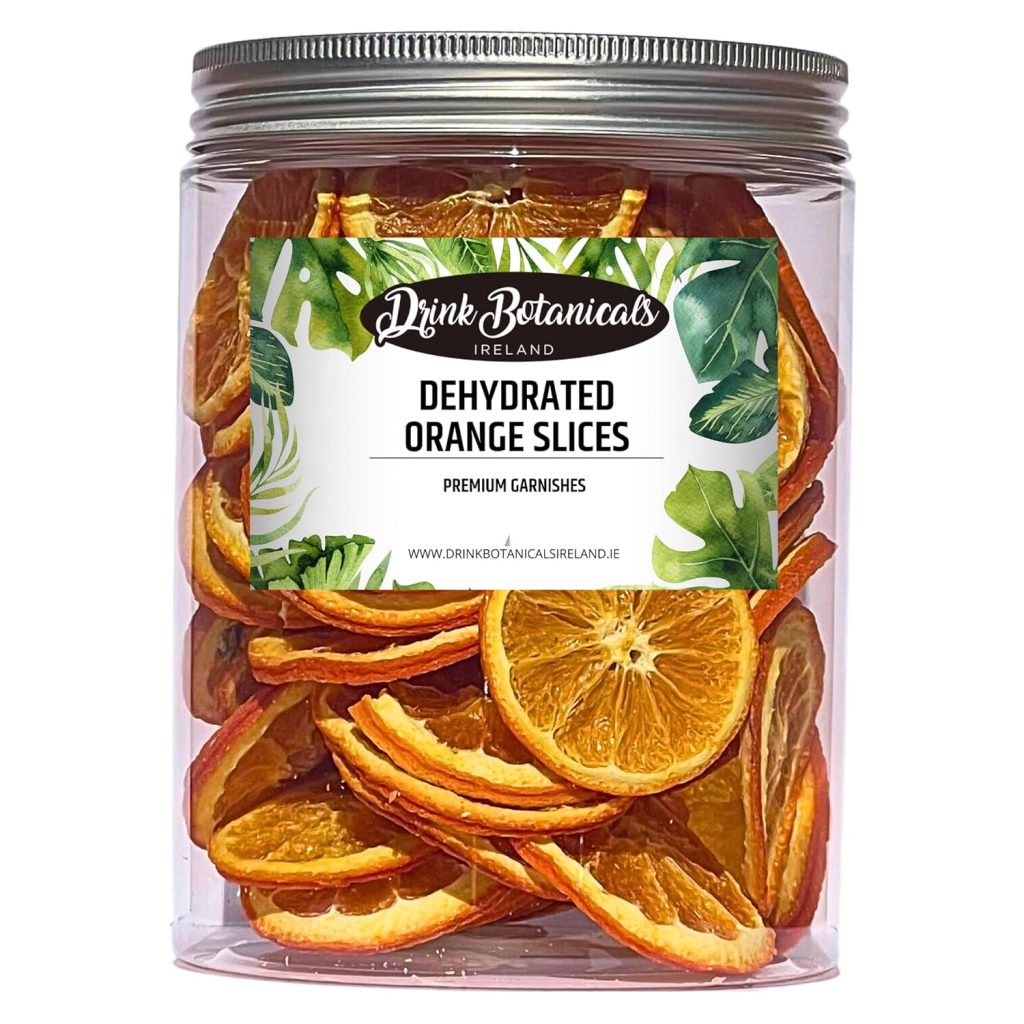 A clear plastic jar filled with dried orange slices. The label reads "Drink Botanicals Ireland - Dehydrated Orange Slices - Premium Garnishes" with green leaf designs, perfect for gift ideas or adding to your favorite simmer pot recipes.