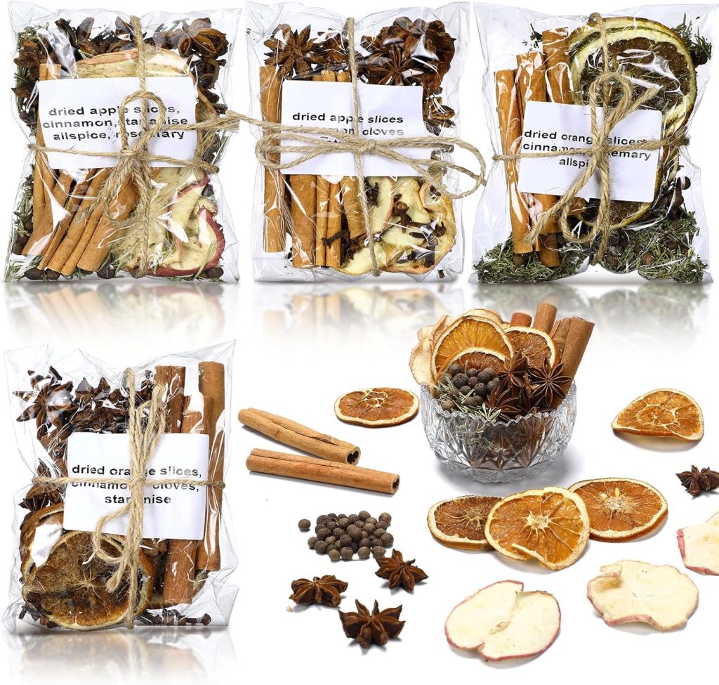 Three clear bags filled with dried apple slices, orange slices, cinnamon sticks, star anise, cloves, and allspice are displayed—perfect for simmer pot gifts. In front, some of the dried ingredients are scattered near a small glass bowl.