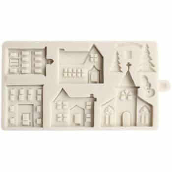 A white silicone mold with five designs: two multi-story buildings, two houses, a church, and a section with pine trees, a hill, and a snowman—perfect for making my favorite Christmas cookies.