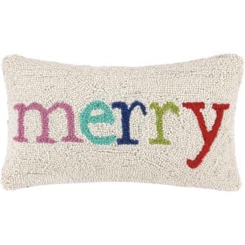 A rectangular white textured pillow with the word "merry" stitched in colorful letters: pink, teal, blue, green, and red, from left to right.