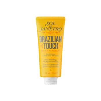 A yellow tube of Sol de Janeiro Brazilian Touch Hand Cream with white cap, featuring orange and black text on the front, standing upright against a white background.