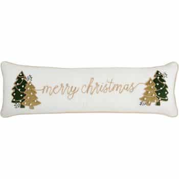 A white rectangular pillow with embroidered gold and green Christmas trees on each end and the words "merry christmas" written in cursive across the center.