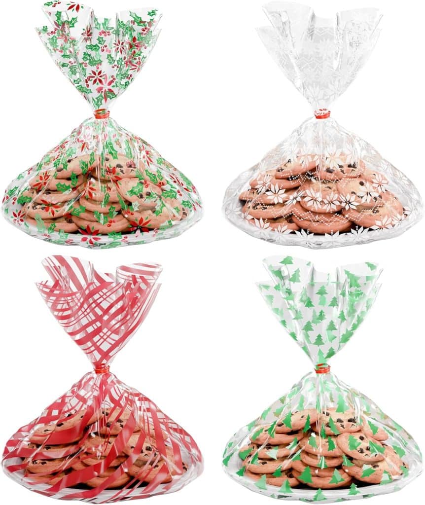 Four clear gift bags filled with cookies, each showcasing a different holiday-themed design—poinsettias, snowflakes, red stripes, and green Christmas trees. Perfect for gifting or trying your favorite molded cookies recipe. The bags are tied at the top.