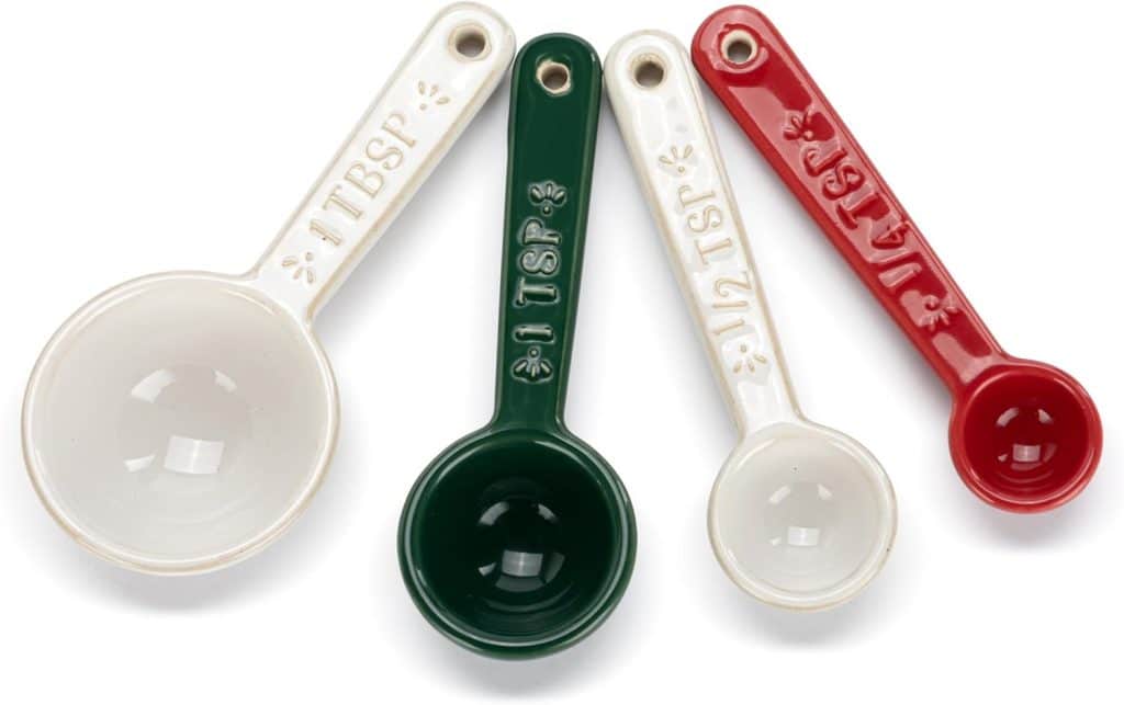 A set of four ceramic measuring spoons in different sizes and colors—perfect for accurate measurements in your favorite molded cookies recipe. Includes white (1 tbsp), green (1 tsp), cream (1/2 tsp), and red (1/4 tsp) arranged side by side.