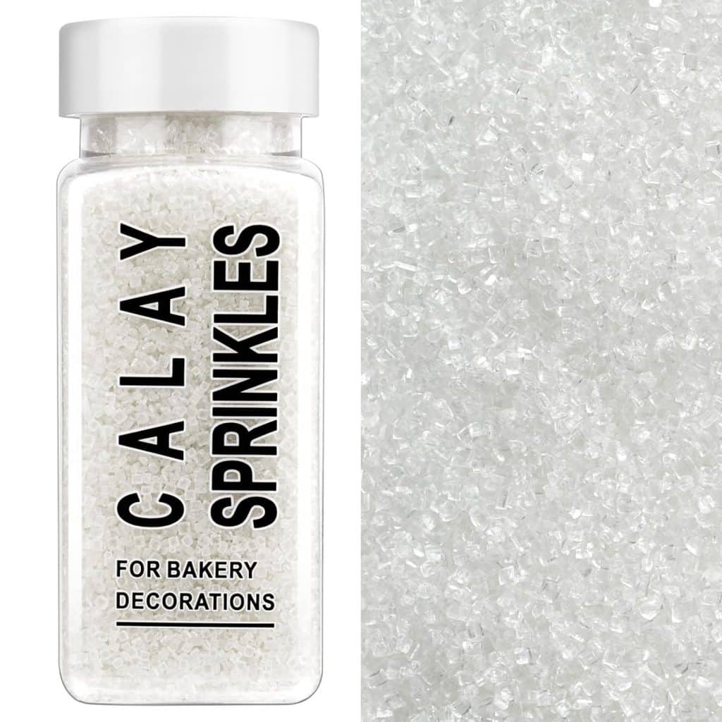A clear bottle labeled "Calay Sprinkles For Bakery Decorations" filled with white decorative sugar sprinkles, shown next to a close-up of the sparkling white sprinkles—perfect for topping your favorite molded cookies recipe.