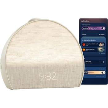 A round, fabric-covered smart alarm clock with a digital time display reads 9:32. Next to it is a smartphone screen showing a sleep routine app with various relaxation and sleep options listed.