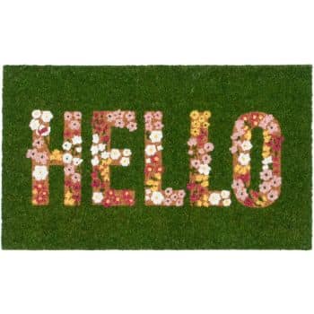 A green doormat with the word "HELLO" spelled out in large letters made of colorful flowers.