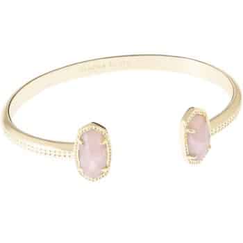 A gold open cuff bracelet featuring two oval, pale pink gemstones on each end, framed in textured gold settings.