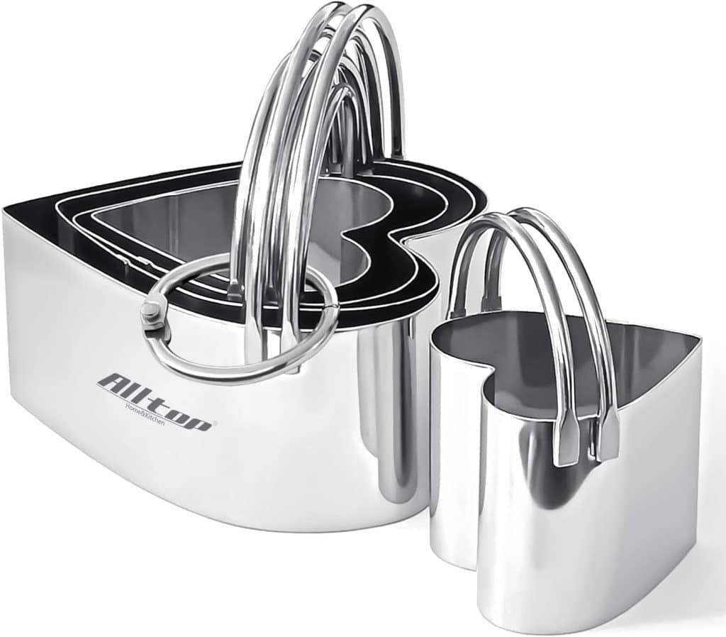 A set of four stainless steel heart-shaped cookie cutters nestled together, each with a top handle. Perfect for shaping treats or following your favorite chocolate covered quinoa recipe, these cutters vary in size and feature a shiny, reflective finish.