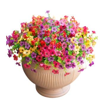 A beige ceramic pot filled with a vibrant mix of small, colorful flowers in shades of pink, purple, red, and yellow, set against a white background.