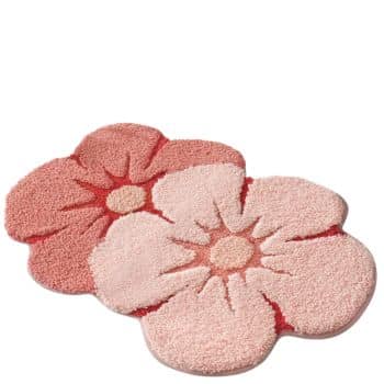 Two fluffy bath mats shaped like flowers, one in a light pink shade and the other in a darker pink, are placed overlapping each other on a white background.