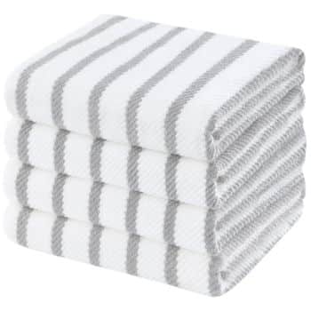 A stack of four white towels with evenly spaced gray stripes, neatly folded on top of each other.