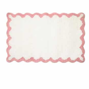 A rectangular white rug with a fluffy texture and a wavy pink scalloped border around the edges.