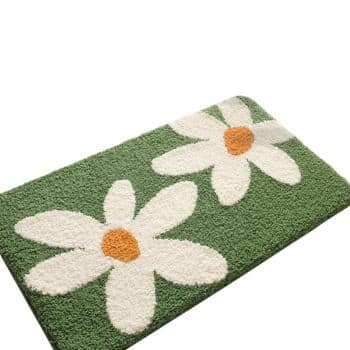A rectangular green rug with two large white daisy flowers, each with an orange center.